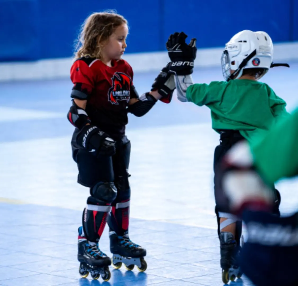 Niños de Uroloki chocando la mano durante un entrenamiento de hockey línea