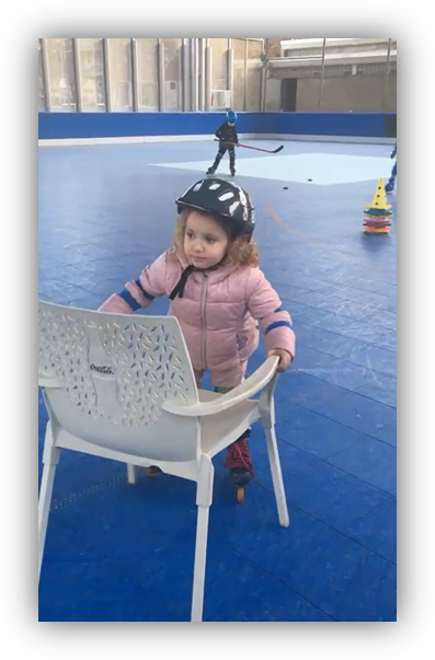 Niña pequeña con casco aprendiendo a patinar durante un entrenamiento de iniciación al hockey línea en Barcelona con Uroloki